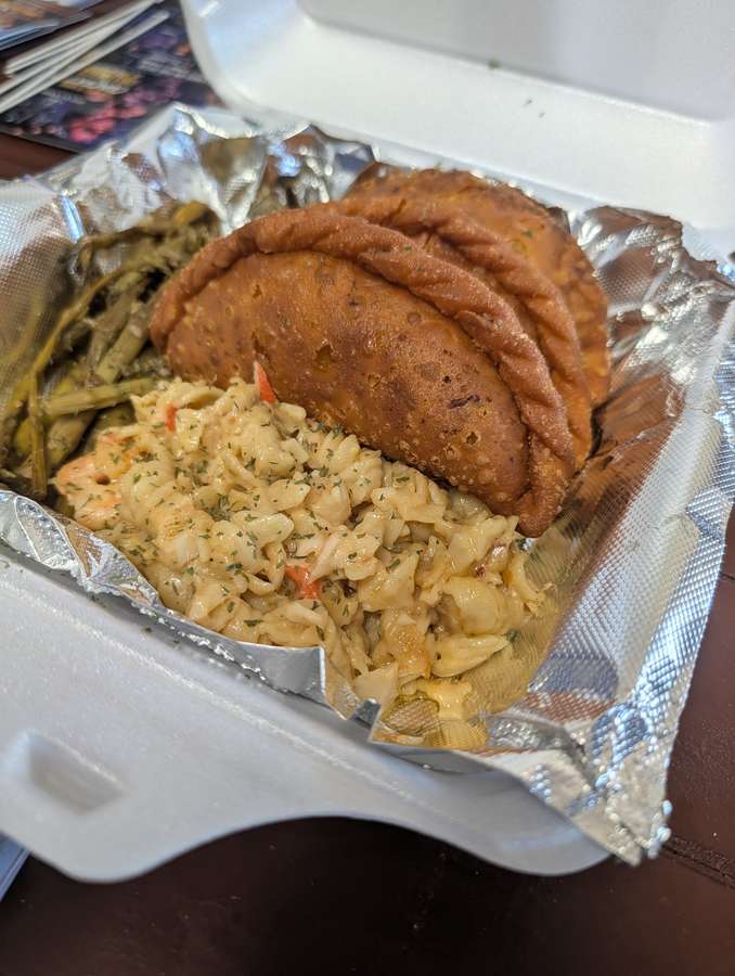 Empanadas served with macaroni and cheese and greens