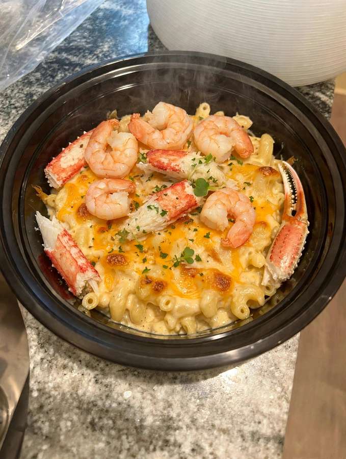 Creamy baked macaroni and cheese topped with shrimp and crab