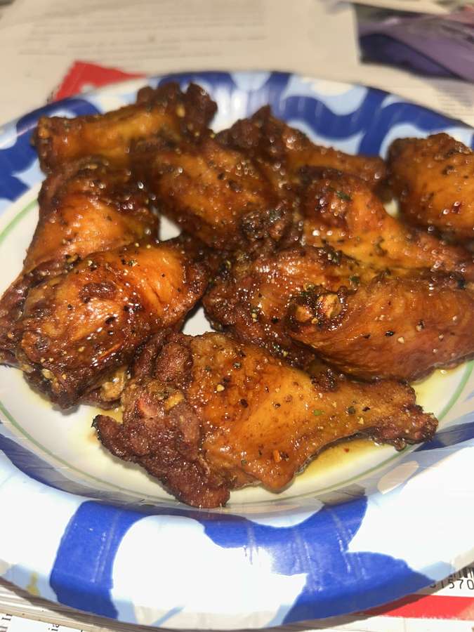 Sauced and seasoned wings served on a plate